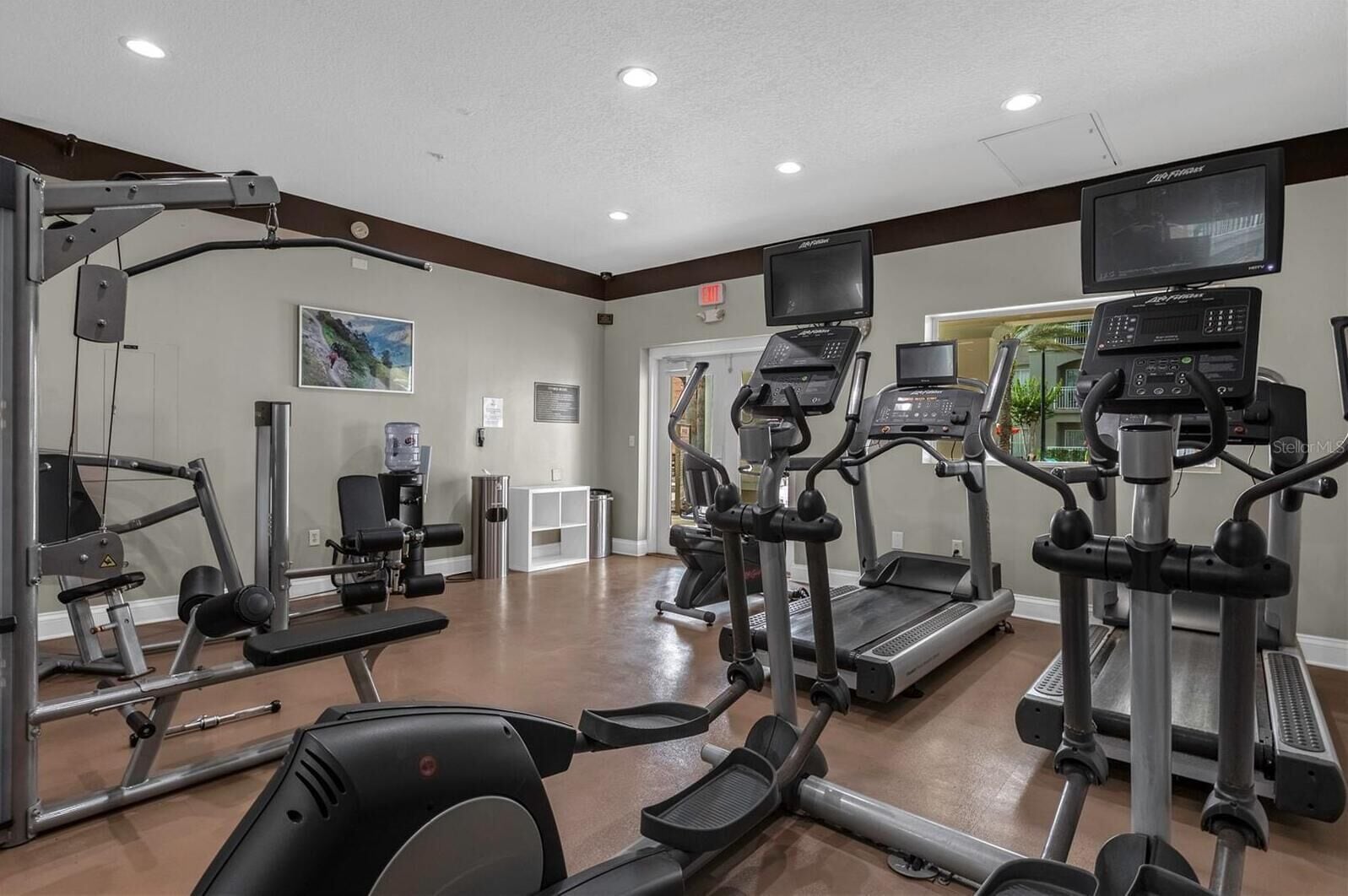 Ein Fitnessstudio mit Laufbändern, Crosstrainern und Krafttrainingsgeräten.
