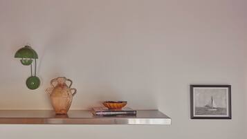 A shelf with a ceramic vase, a bowl, and a framed picture.