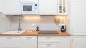 A kitchen with white cabinets, a microwave, a coffee maker, and a sink. - Apartment 'Relax Porto Mannu' with Sea View, Wi-Fi and Air Conditioning (Palau)