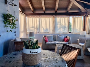 A cozy room with wicker furniture, a round table, and a potted plant with 'home' on it.