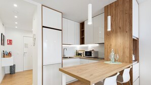 Une cuisine moderne avec des armoires blanches, un plan de travail en bois et un four à micro-ondes.