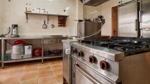Cozinha com eletrodomésticos de aço inoxidável, incluindo fogão, forno e geladeira.