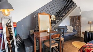 A staircase with a black metal railing, a wooden dining table with chairs, a sofa, and a lamp. - Studio Apartment 'Villa Cangiani - La Lavanda' with Mountain View and Wi-Fi (Massa Lubrense)