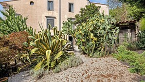 A building with a flat facade, multiple windows, and a gravel pathway leading to a wooden structure. - Studio Apartment 'Villa Cangiani - La Lavanda' with Mountain View and Wi-Fi (Massa Lubrense)