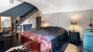 A bedroom with a bed, a desk, a chair, a mirror, a staircase, and a nightstand with a lamp. - Studio Apartment 'Villa Cangiani - La Lavanda' with Mountain View and Wi-Fi (Massa Lubrense)