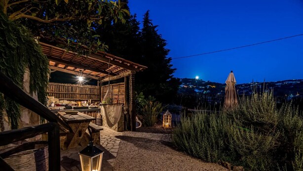 A rustic outdoor seating area with a pergola, stone tables, and lanterns. - Studio Apartment 'Villa Cangiani - La Lavanda' with Mountain View and Wi-Fi (Massa Lubrense)