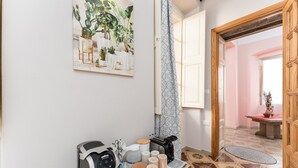 A kitchen with a coffee maker, toaster, and mugs on a tray, a potted plant, and a door leading to another room. - Studio 'Pistiddu' with Shared Garden, Wi-Fi, and Air Conditioning (Dorgali)