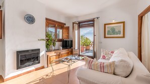 Una sala de estar con chimenea, un sofá, una mesa de centro y vistas al exterior.