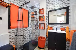 A bathroom with a shower, a sink with a mirror, and shelves with toiletries. - Apartment 'Casa Margara' with Wi-Fi and Air Conditioning (Chipiona)
