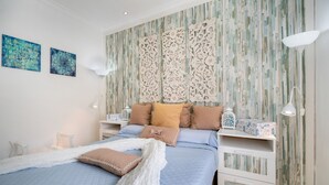 A bedroom with a bed, nightstands, and a decorative headboard.