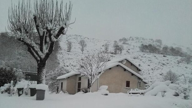 A snow-covered rural house with a large tree in front, surrounded by a snowy landscape. - Holiday Home 'Gîte Le Suquet' with Mountain View and Private Terrace (Dourbies)
