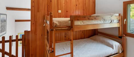 Un lit superposé avec une structure en bois et un matelas à motifs.