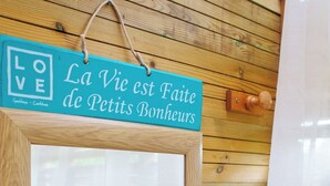 Una pared de madera con un letrero que dice 'La Vie est Faite de Petits Bonheurs' y una puerta de madera.