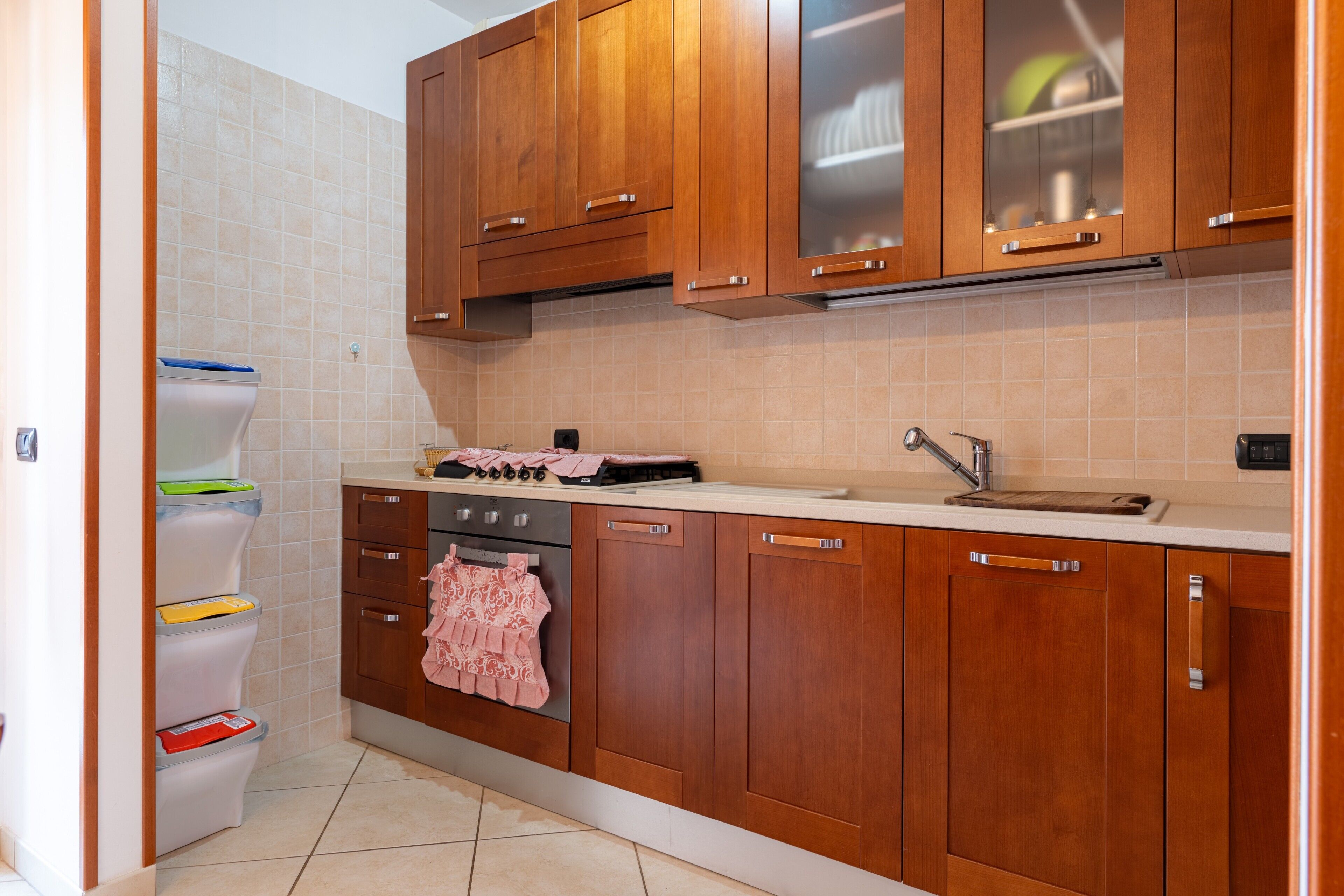 A kitchen with wooden cabinets, a sink, a stove, and a dishwasher.
