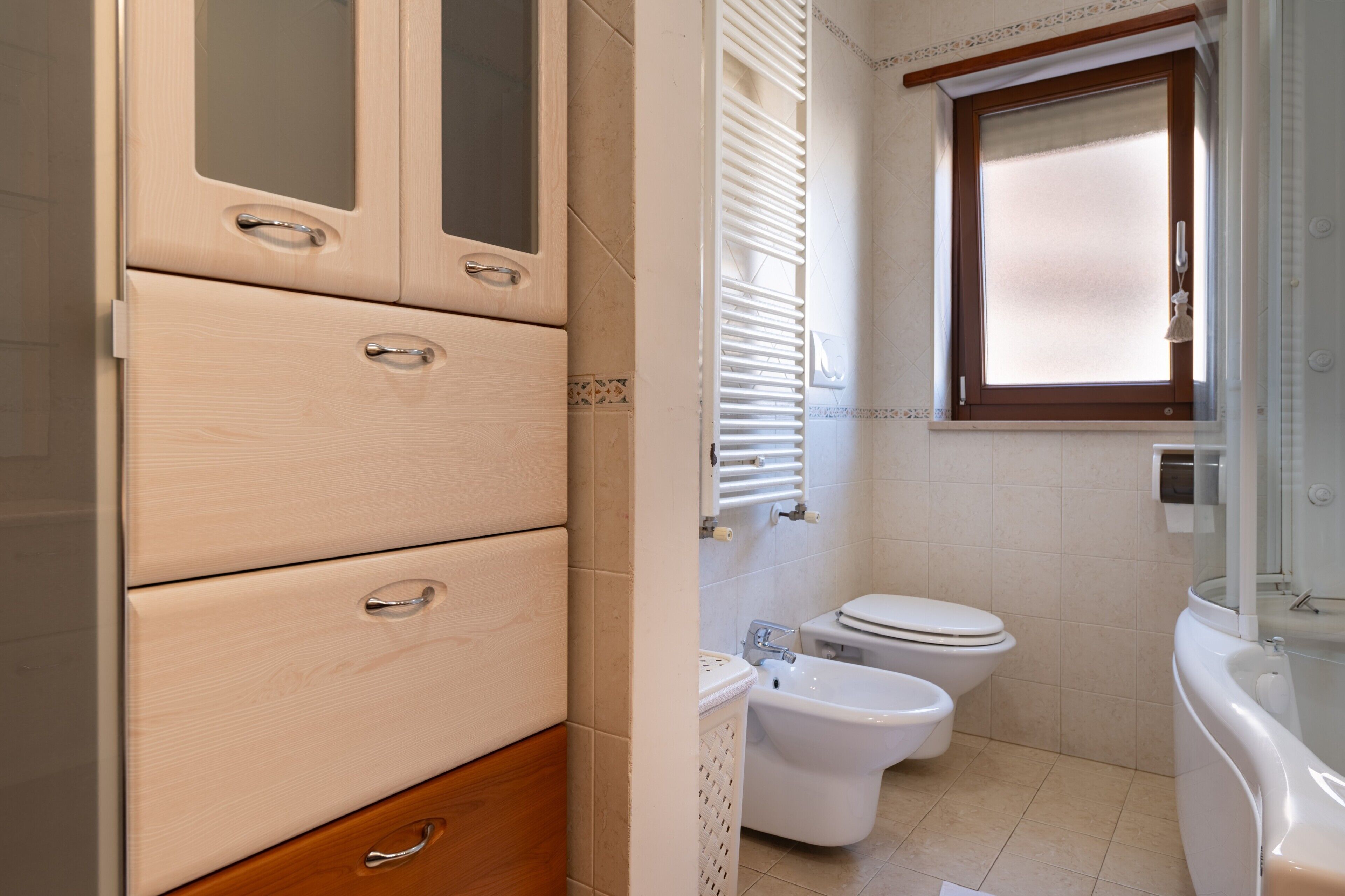 A bathroom with a toilet, bidet, and bathtub.