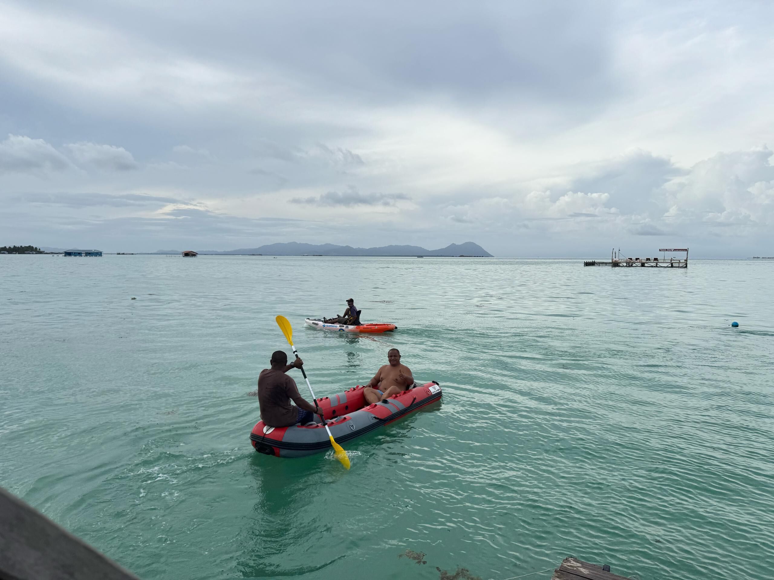 A calm body of water with kayaks and a paddleboard.