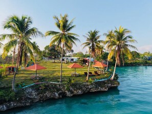A tropical resort with palm trees, a pool, and outdoor seating areas. - Panglima Resort Bum Bum Island, Semporna (Bum Bum Island)
