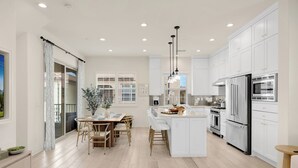 A modern kitchen with white cabinets, stainless steel appliances, and a central island. - Modern Grand Luxury Estate in Irvine with Pool & Amenities  (Irvine)