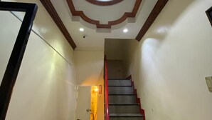 Un escalier surmonté d’une lucarne circulaire et orné de moulures en bois.