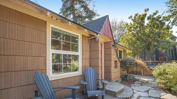 A house with a wooden exterior, a stone pathway, and two Adirondack chairs. - Charming Historical Home in Downtown Boise (Boise)