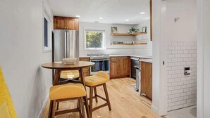 A compact kitchen with wooden cabinets, a built-in oven, and a window providing natural light. - Charming Historical Home in Downtown Boise (Boise)