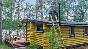 A log cabin with a wooden deck, a chimney, and a ladder leaning against the cabin. - Lammenranta by Interhome (Rautalampi)
