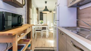 A compact kitchen with a microwave, sink, and wooden cabinets. - Lammenranta by Interhome (Rautalampi)