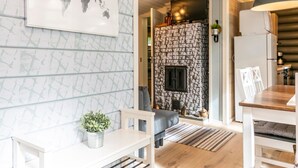 A modern living room with a world map artwork, a fireplace, and a dining area with a wooden table and chairs. - Lammenranta by Interhome (Rautalampi)