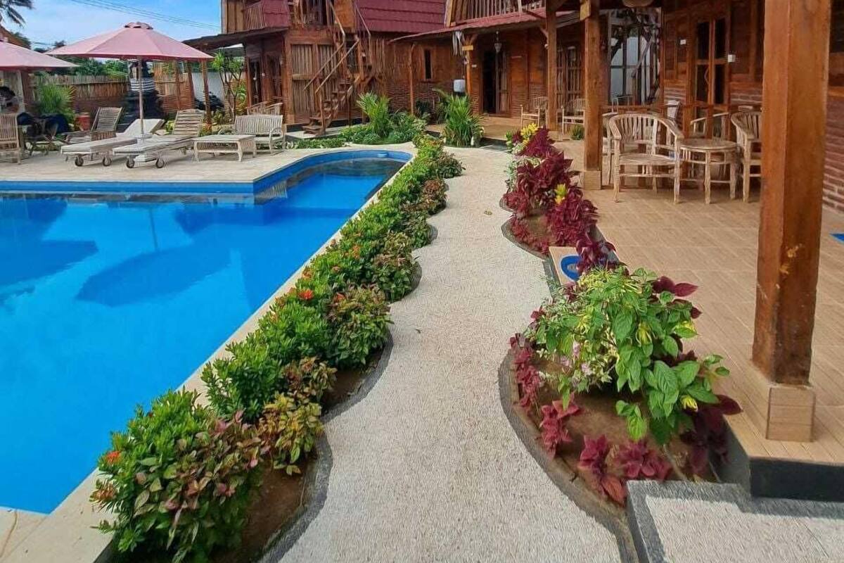 A wooden building with a pool and outdoor seating area.