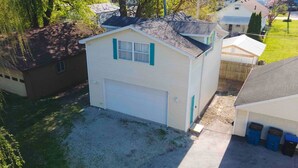 A single-story house with a garage, a small front yard, and a neighboring house. - The Perch- 1 bedroom guest studio above garage (Oregon)