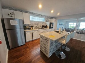 Enjoy cooking in this well-lit kitchen with a central island and stainless steel appliances.