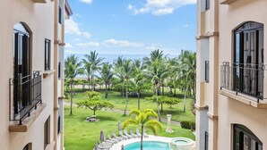 A pool area with lounge chairs and a view of the ocean. - Jaco Beachfront Elegance at Tres Regalos Pristine Views in Lovely Jacó Beach (Jacó)