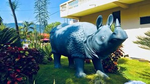 A large blue elephant statue in a garden with a building in the background. - The Narayani Resort (Gaindakot)