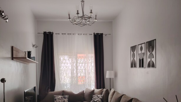 Un soggiorno moderno con un divano componibile, un tavolino da caffè, una televisione e un lampadario.