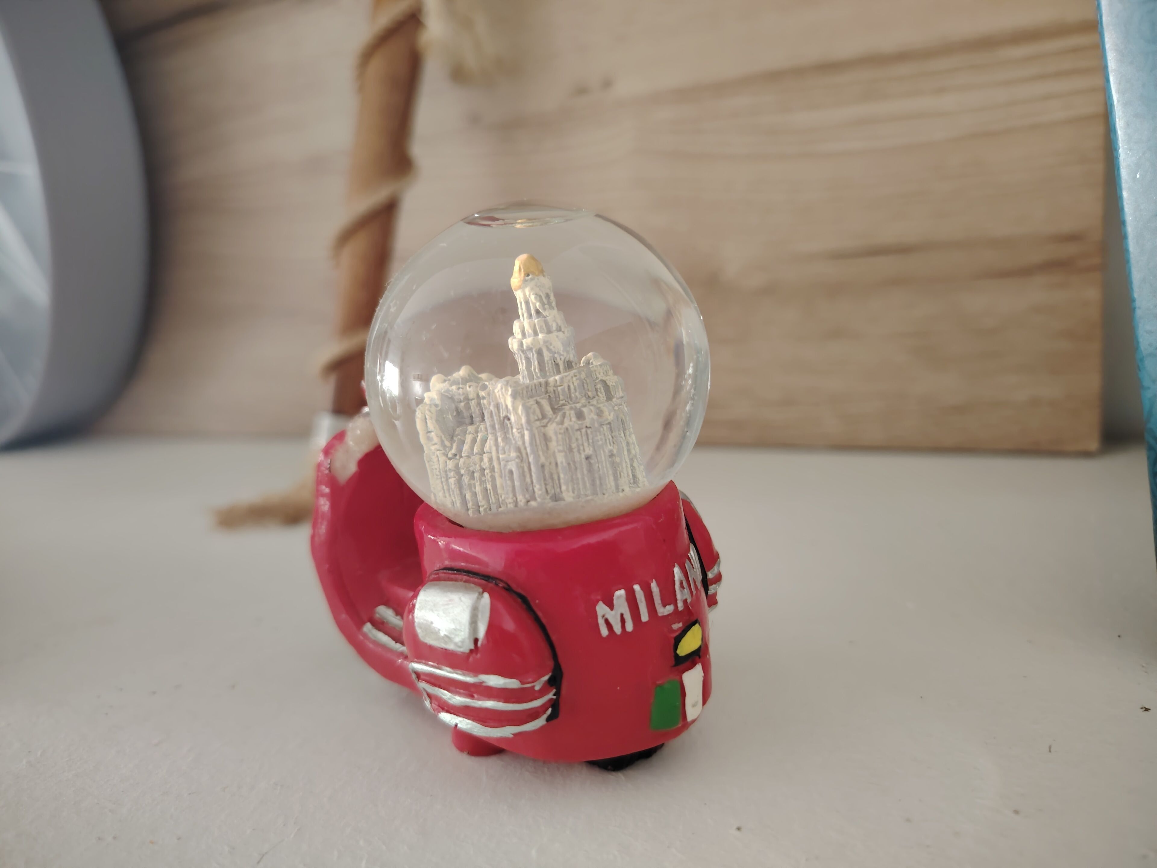 A red toy car with a clear dome on top, featuring a detailed cityscape inside.