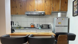 Keittiössä on puukehikoiset kaapit, ruostumattomasta teräksestä valmistettu liesituuletin, kaasuliesi, vedenkeitin, leivänpaahdin ja jääkaappi. Siellä on myös kaksi mustaa baarijakkaraa, joiden istuimet ovat puuta ja jalat metallia.