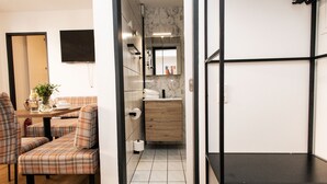 Een modern interieur met een eethoek, een kitchenette en een badkamer.