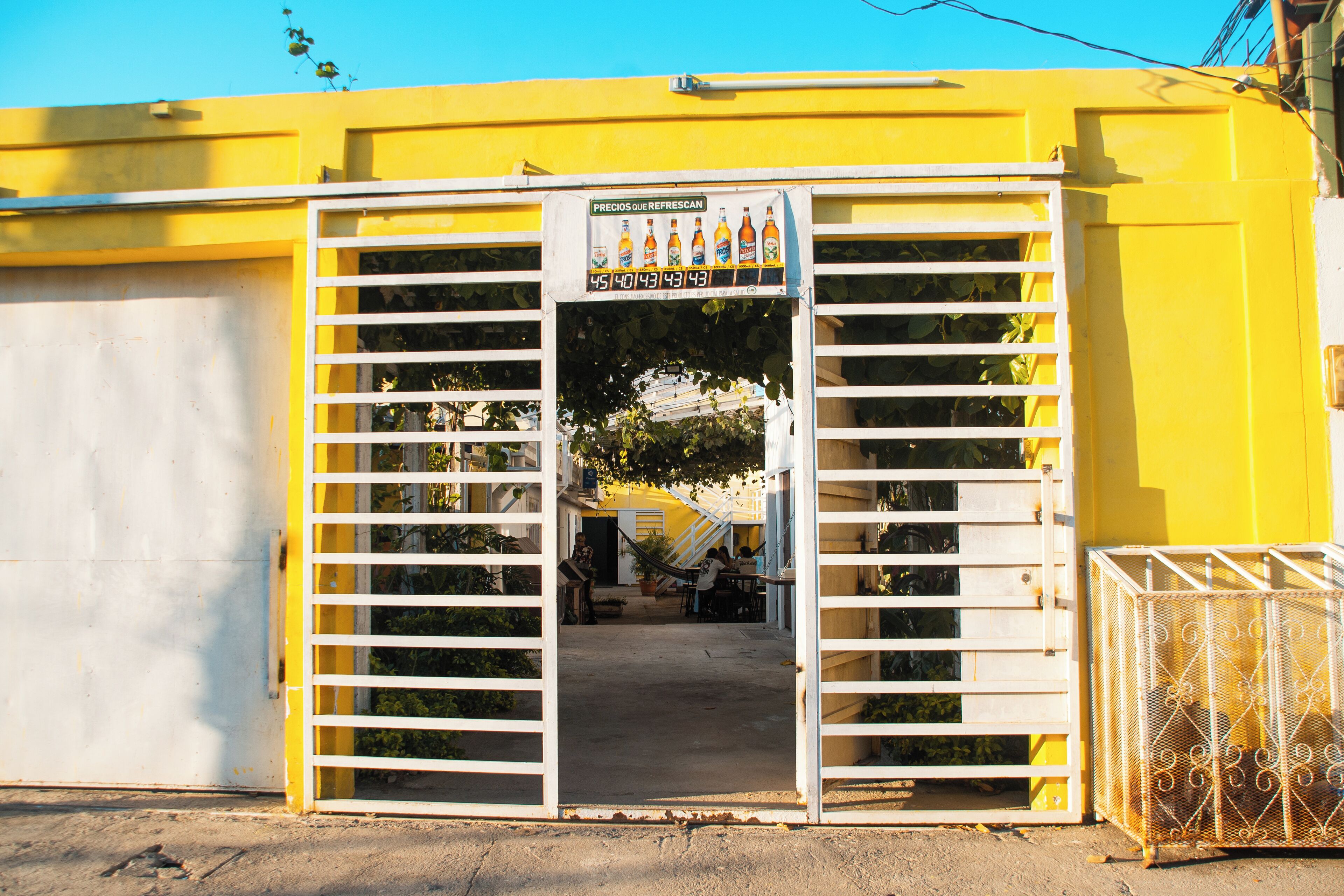 Un edificio amarillo con un cartel que anuncia bebidas.