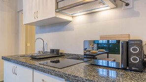 Een keuken met een granieten aanrechtblad, een ingebouwde oven, een spoelbak en een ProClean 3040 Mirror.