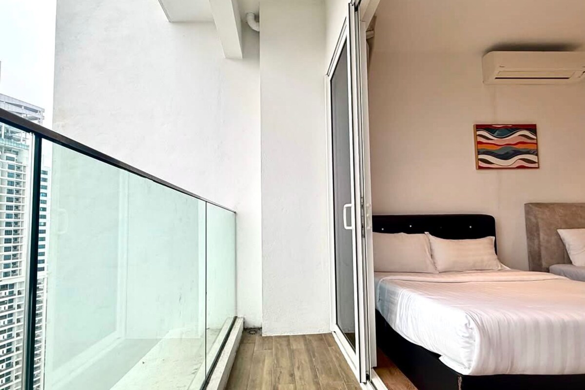 A bedroom with a bed, a window, and a view of a building.
