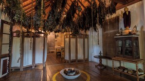 A traditional room with wooden floors, a central fire pit, and hanging plants. - Lady Hill Hotel (Galle)