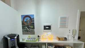 A kitchen counter with a coffee maker, toaster, and a neon bicycle sign. - Bed&BikeRome ANGELICO  (Rome)