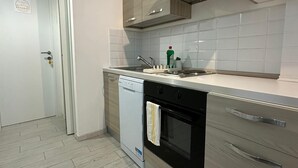 A modern kitchen with a dishwasher, oven, and wooden cabinets. - Bed&BikeRome ANGELICO  (Rome)