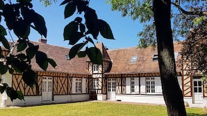 Un bâtiment traditionnel à colombages, doté d’une façade symétrique, de nombreuses fenêtres et d’une entrée centrale.