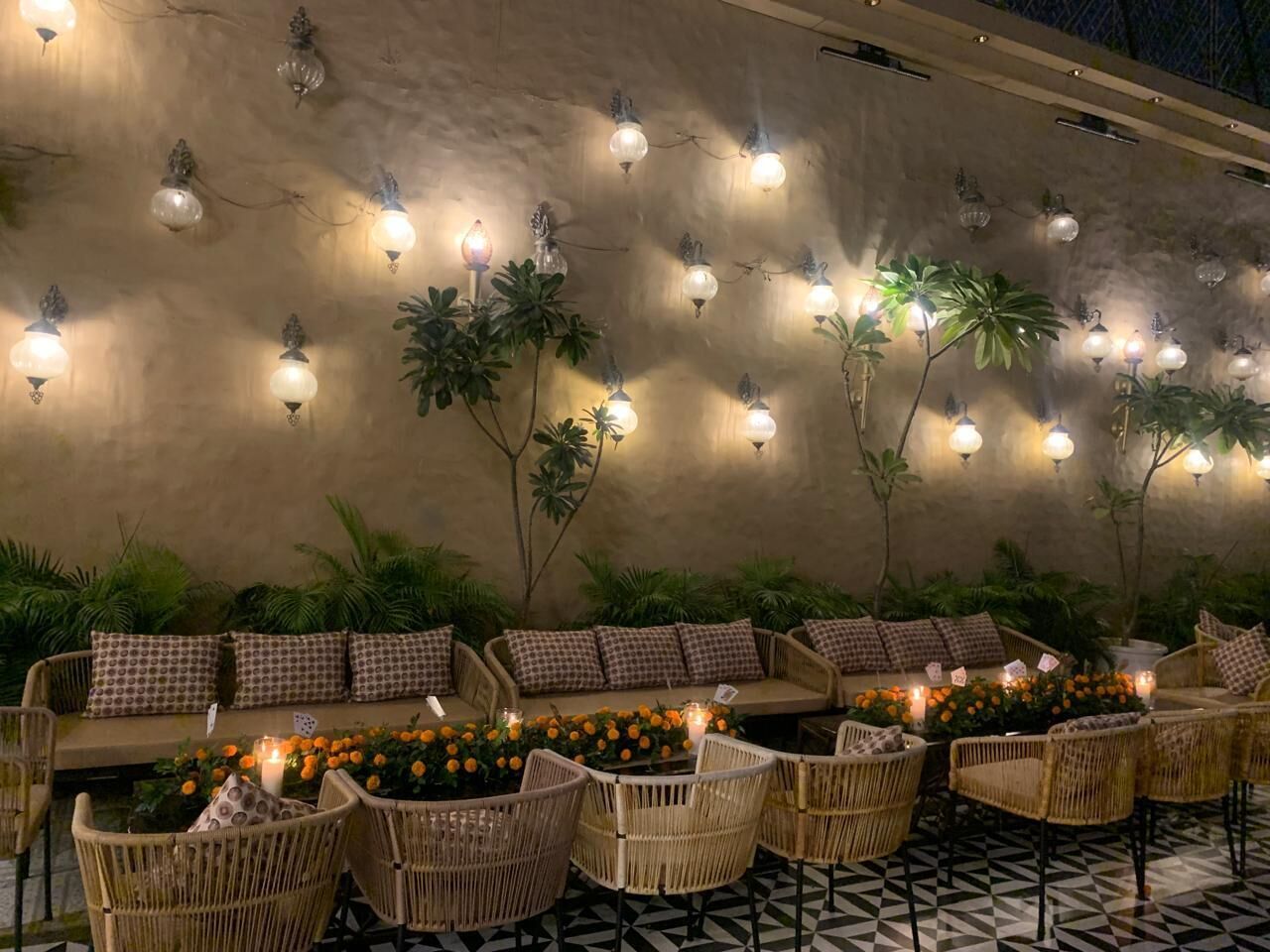 An outdoor seating area with wicker furniture and a patterned floor.
