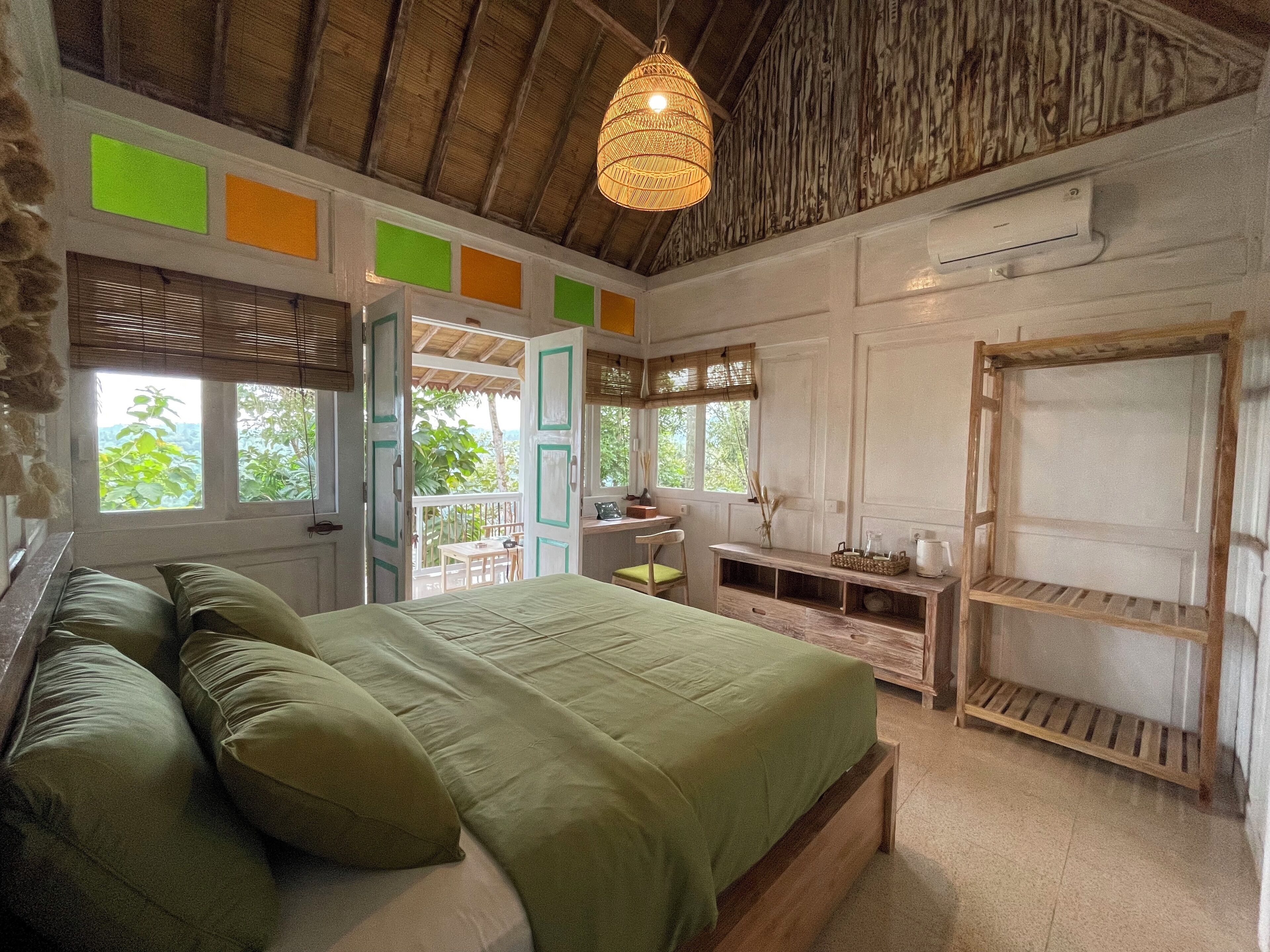 A bedroom with a bed, a desk, and a wardrobe.
