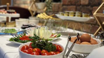 Een buffet met diverse gerechten, waaronder salades, fruit en eieren.