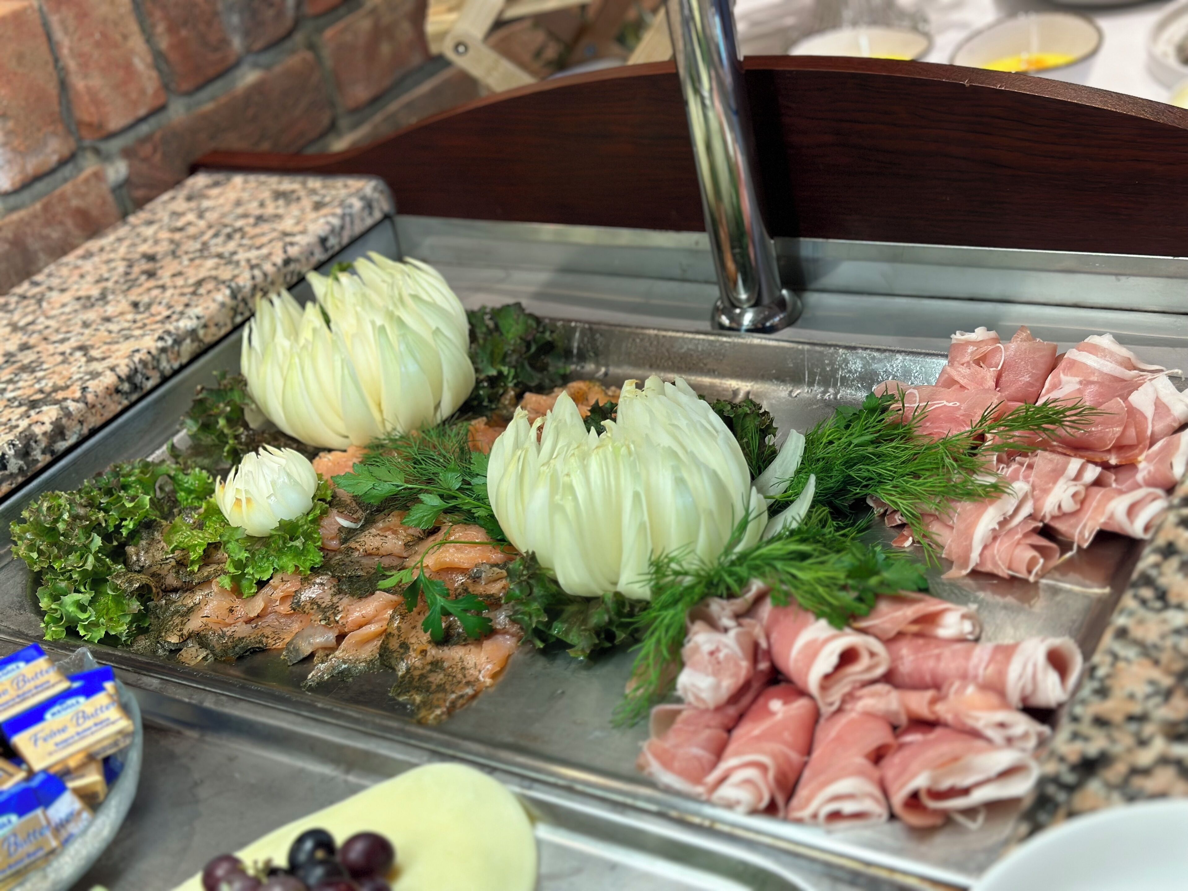 Ein Buffet mit Lachs, Schinken, Artischocken und Salat.