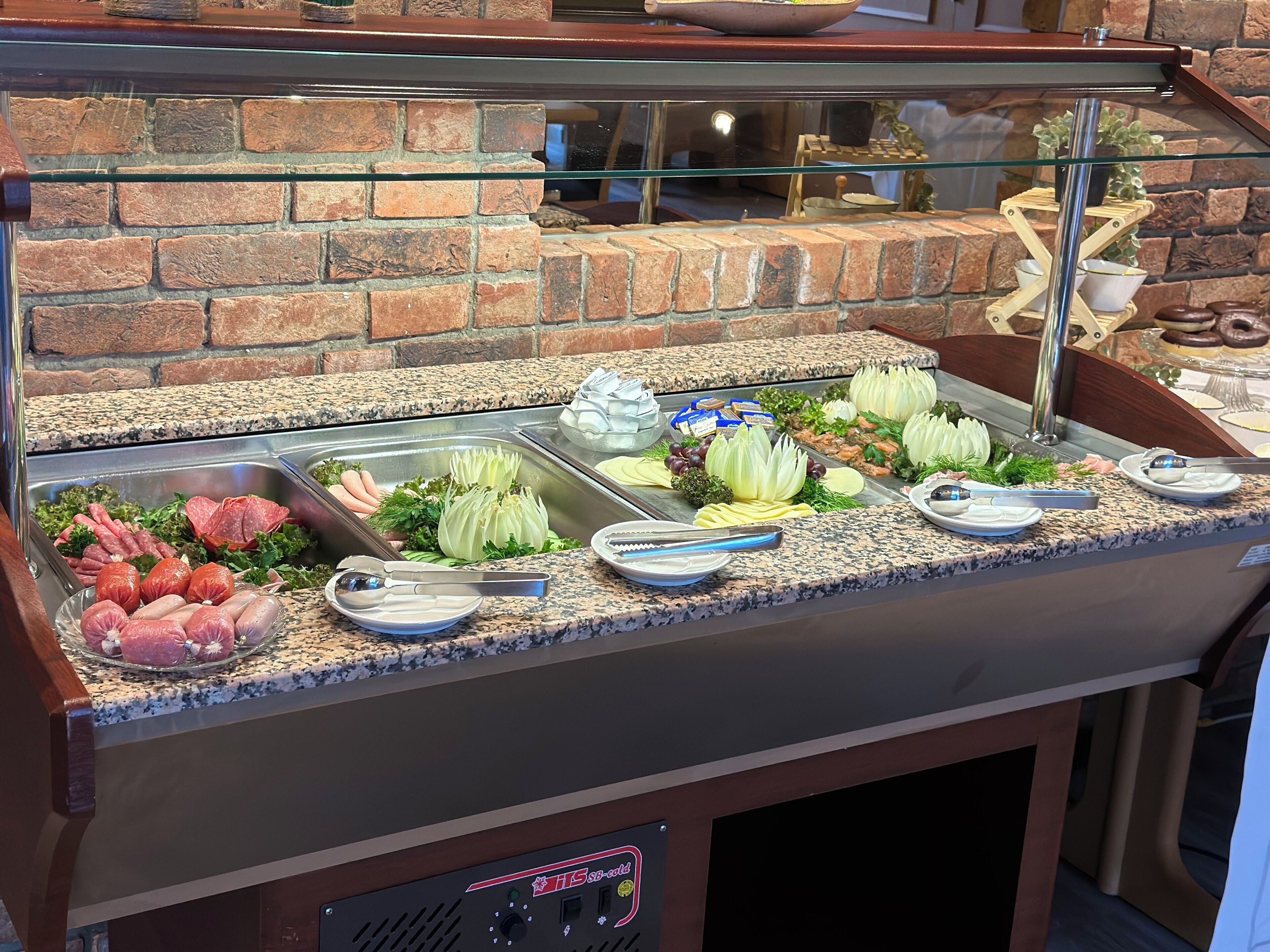 A buffet with various food options including meats, cheeses, and vegetables.