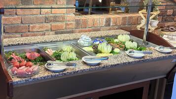 A buffet with various food options including meats, cheeses, and vegetables.